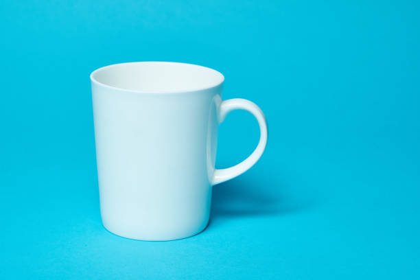 istock White ceramic glass isolated on a blue background. copy space and Simplicity 1302334408