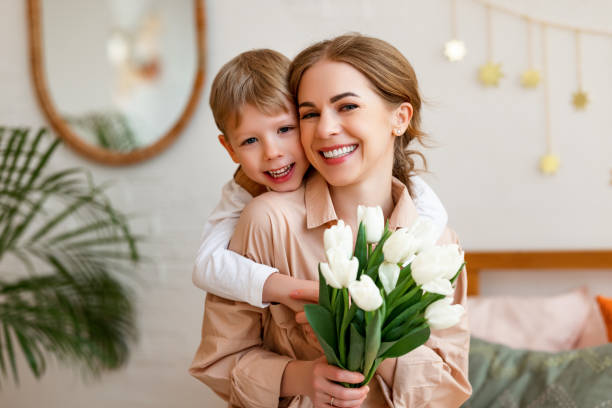 istock Happy son hugging mother with flowers 1302334506