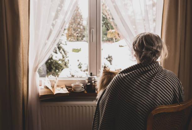 istock Old retired woman (senior) by the home window - retirement concept 1302335570