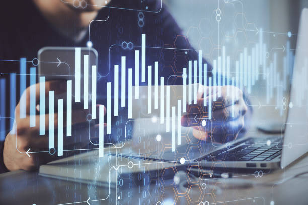 istock Double exposure of man's hands holding and using a phone and financial graph drawing. Analysis concept. 1302336725