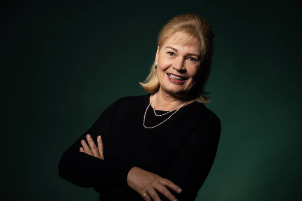 istock Happy senior woman on green background 1302336794