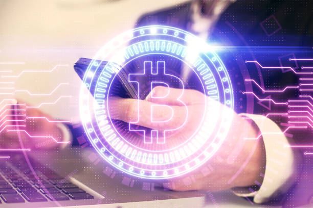 istock Double exposure of man's hands holding and using a phone and crypto currency blockchain theme drawing. 1302336849