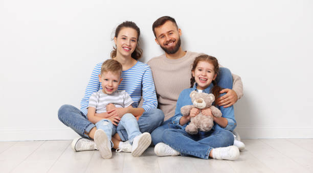 istock Happy parents with kids sitting in empty room 1302337557
