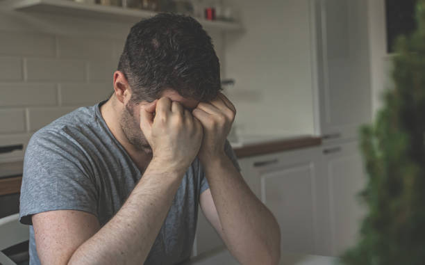 istock Tired upset man sitting in the kitchen. 1302337843