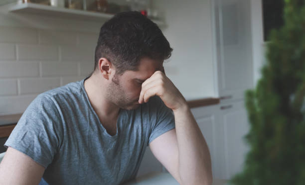 istock Tired upset man sitting in the kitchen. 1302337847