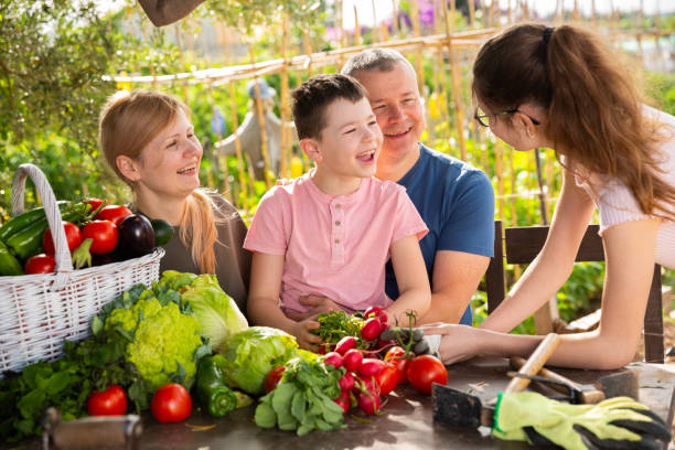istock Parents with children relax at rustic table after harvesting vegetables 1302338186