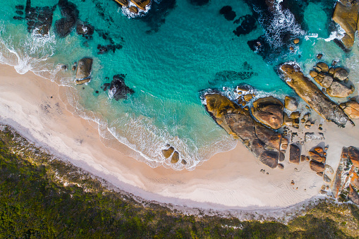 Aerial view of rocky coastline with beach and aqua marine blue water