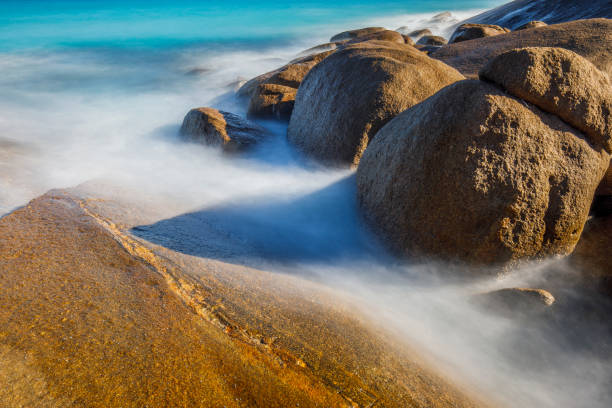 Ocean water flowing over golden rocks