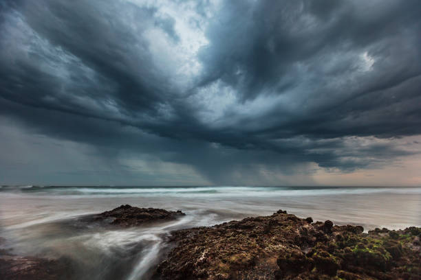 istock Ocean waves flowing over rocks at sunrise with dramatic storm clouds 1302341032
