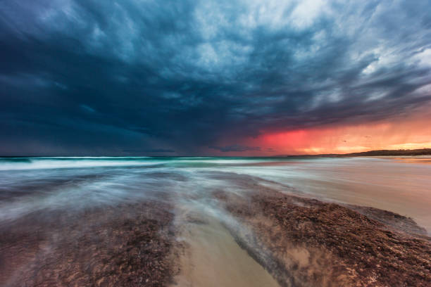 istock Ocean waves flowing over rocks at sunrise with dramatic sky 1302341172