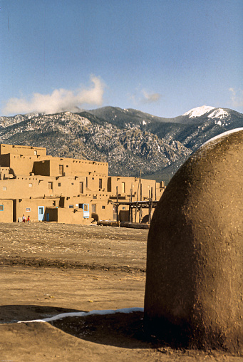 The peak of Taos Mountain is Taos, NM is snow capped. Below the mountain which is located in the Sangre de Cristo mountain range, the ancient Taos Pueblo sits. This pueblo is considered to be one of the oldest continuously inhibited communities in the US.