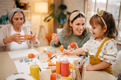 Happy family painting easter eggs at home, warm home atmosphere