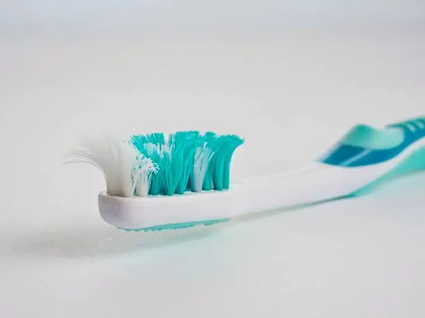 Old toothbrush used beyond it's service life. Curled bristles indicate the brush is less effective.