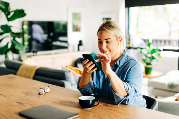 istock Woman in Kitchen with Smart phone and coffee cup 1302348028