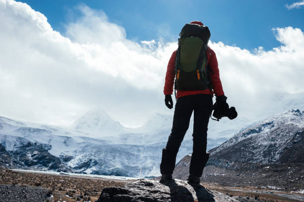 istock Woman hiker with camera in winter high altitude mountains 1302348892
