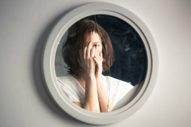 reflet du visage d’une femme dans le miroir cassé. concept de dépression, d’anxiété, de phobie, de suicide et de santé mentale. - mirror reflection blues glass photos et images de collection