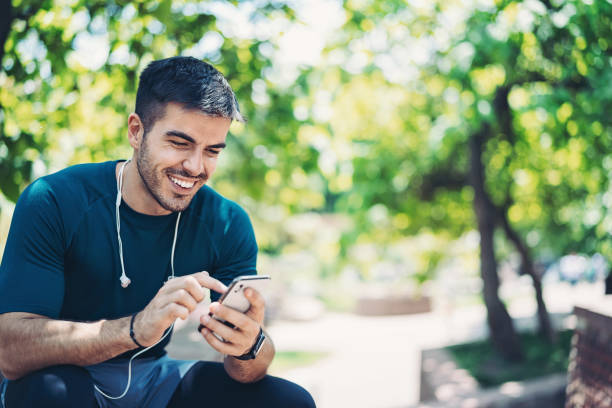 istock Sportsman using smart phone in the park 1302354406