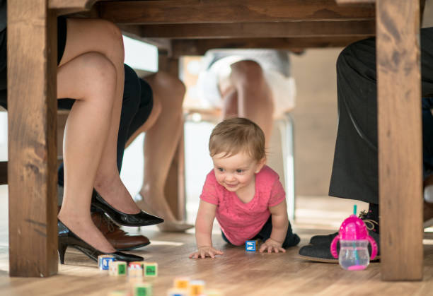 Young toddler crawling under boardroom table