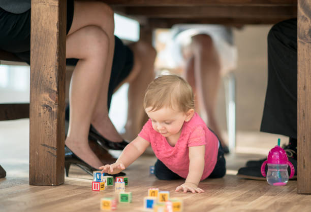 istock Young toddler crawling under boardroom table 1302357097