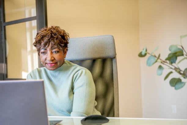 istock Senior woman using a laptop in an office 1302357319