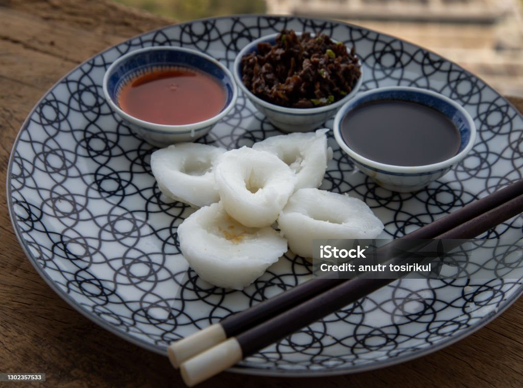 Close-up of Homemade Chinese Steamed Dumplings with Radish (Jui Guay or Chwee Kueh). Close-up of Homemade Chinese Steamed Dumplings with Radish (Jui Guay or Chwee Kueh) aten with pickled turnip, daikon, crumbs, bird's eye chili and black sauce. Selective focus. Appetizer Stock Photo