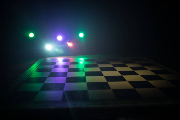 istock empty chess board with smoke float up on dark background with colorful backlight. 1302358509