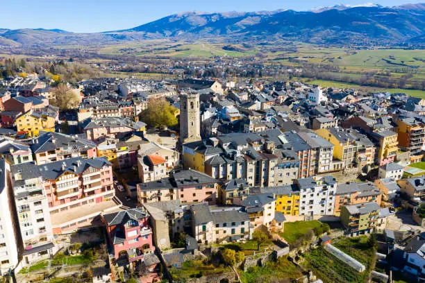 Panoramic aerial view of Puigcerda townscape overlooking medieval bell tower of ruined Santa Maria church in sunny autumn day, Girona, Spain