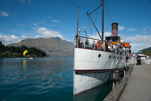 Queenstown New Zealand - March 1 2015; TSS Earnslaw tourist passenger classic steamship at wharf with passengers boarding while preparing to take tourists on lake cruise.
