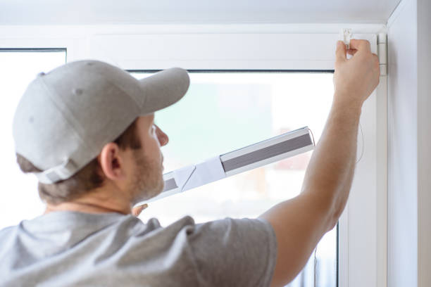 istock Man installing gray pleated blinds on the window 1302367681