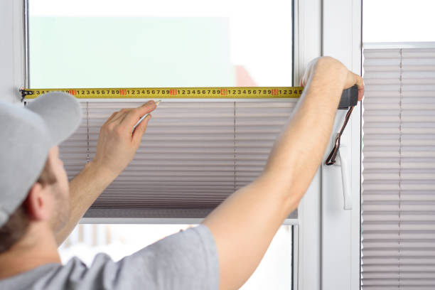 istock Man installing gray pleated blinds on the window 1302367688