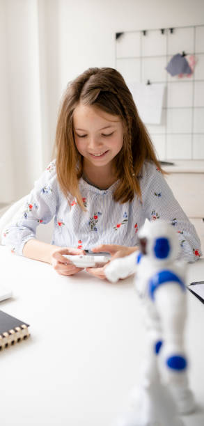 istock young, blond schoolgirl is playing with her robot toy 1302372457