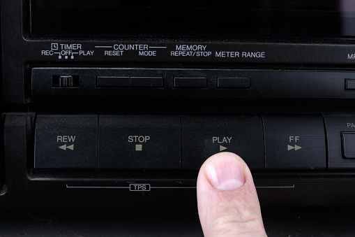 Press play button on retro audio cassette tape recorder.