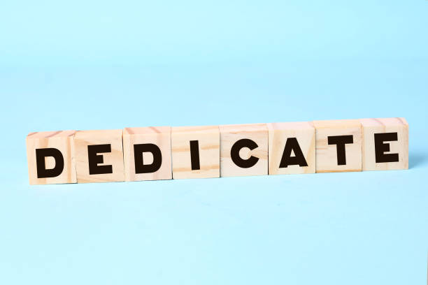 istock Word Dedicate on a row of wooden blocks. Devotion dedication love concept 1302379177