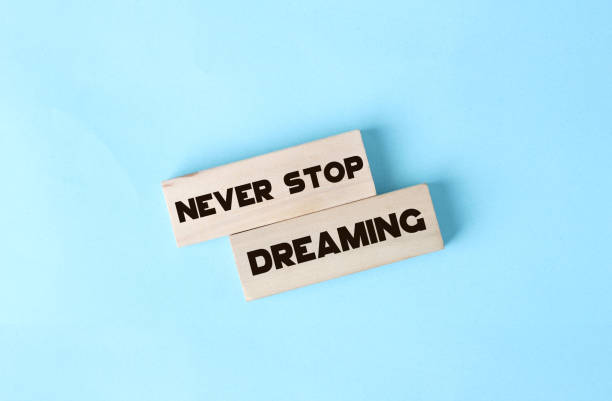 istock Never stop dreaming words printed on wooden blocks on soft pink. Positive thinking mindset concept 1302379316