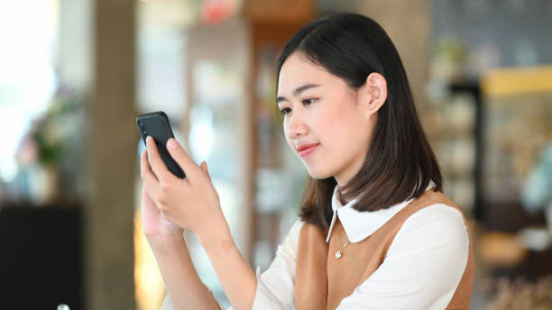 istock Young female using mobile phone surfing internet at coffee shop. 1302380203
