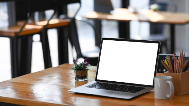 istock Open computer laptop with empty screen, coffee cup, plant and stationery on wooden table. 1302381011