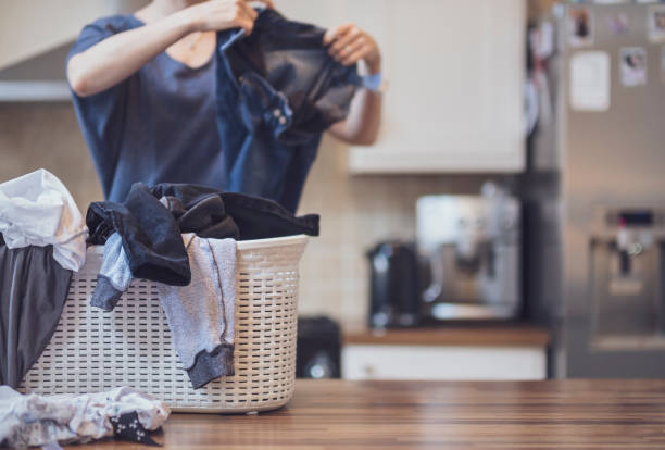 Folding Laundry at Home A woman is busy folding laundry in her kitchen. drudgery photos stock pictures, royalty-free photos & images
