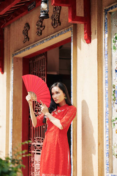istock Asian woman posing with paper fan 1302382500