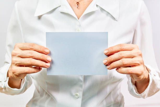 istock Business woman holding empty blue card on white background. 1302387725