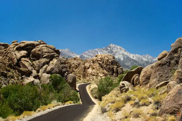 "Alabama Hills" with a winding road and the Sierra Nevada in the background during summer time, famous place for famous movie filming location