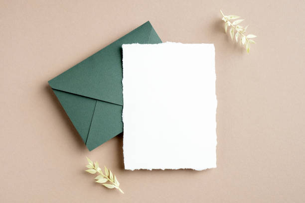 istock Rustic wedding invitation card mockup, green envelope and dried flowers on pastel beige background. Flat lay, top view, copy space. 1302395319