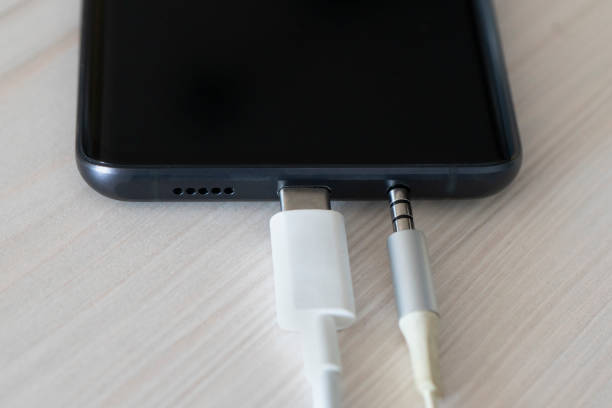 caricabatterie per telefoni cellulari ravvicinato con usb type-c usb-c. caricabatterie per cavi di tipo c e porta del telefono. connessione jack audio da 3,5 mm a un telefono cellulare nero. - human settlement audio foto e immagini stock