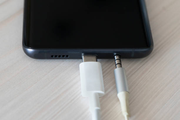 Close up Mobile phone Charger with USB Type-C USB-C. type C cable charger and port of the phone. Connection 3.5 mm audio jack to a black mobile phone. Close up Mobile phone Charger with USB Type-C USB-C. USB type C cable charger and port of the phone. Connection 3.5 mm audio jack to a black mobile phone. usb port photos stock pictures, royalty-free photos & images