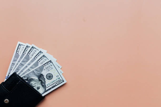 istock Bundle of dollars in purse on beige background 1302400140