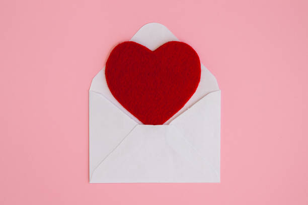 istock Red heart in a white envelope on a pink background. 1302400399
