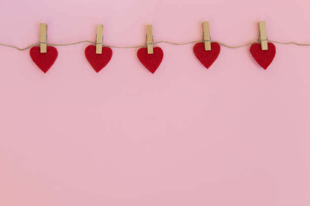 istock Red hearts hanging on the clothesline on pink background. 1302400647