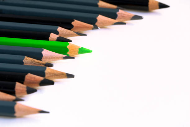 istock colored green pencil among gray and black pencils 1302401567