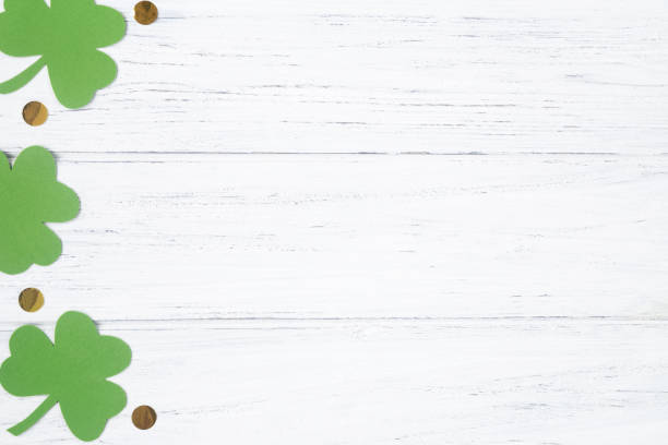 istock Patricks day background, flat lay with copy space. Green clover leaves with golden glitters on the white wooden table 1302401986