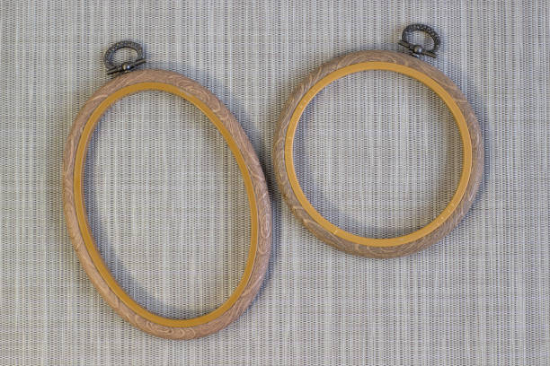 istock Embroidery hoop, oval and round frames on rough grey linen, top view close up 1302402046