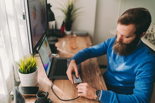 Businessman unlocking external hard disk drive with fingerprint authentication